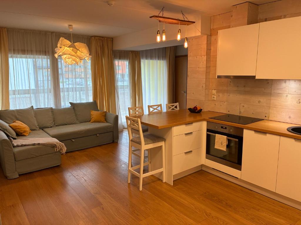a kitchen and living room with a couch and a table at Viimsi Apartment in Haabneeme