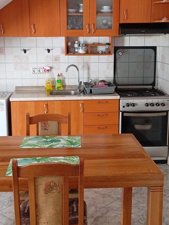 a kitchen with a table and a sink and a stove at Apartman Mare in Kaštela