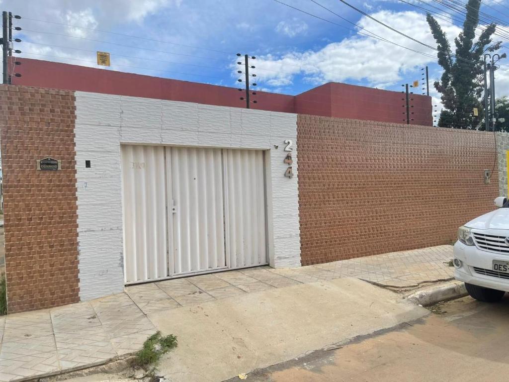 a garage with two white doors on a brick building at Casa in Petrolina