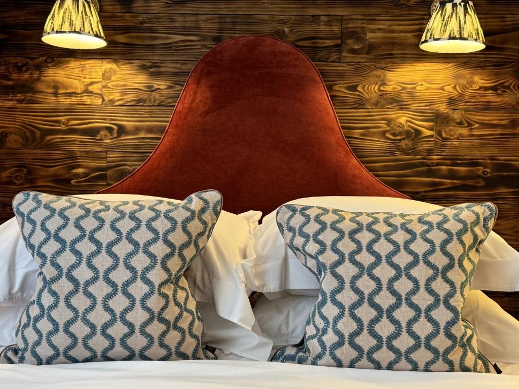 a bed with two pillows and a red head board at East Beach Guest House in Littlehampton