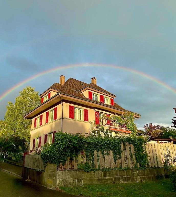 a rainbow over a house with at Gästehaus Sonne in Zuchwil