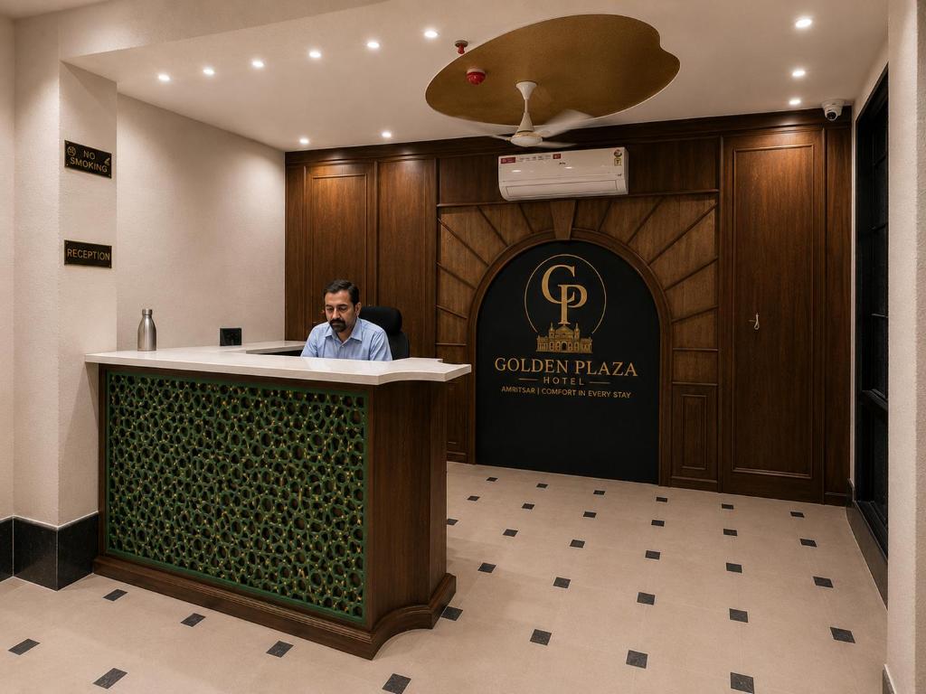 a man sitting at a podium in a lobby at Hotel Golden Plaza in Amritsar