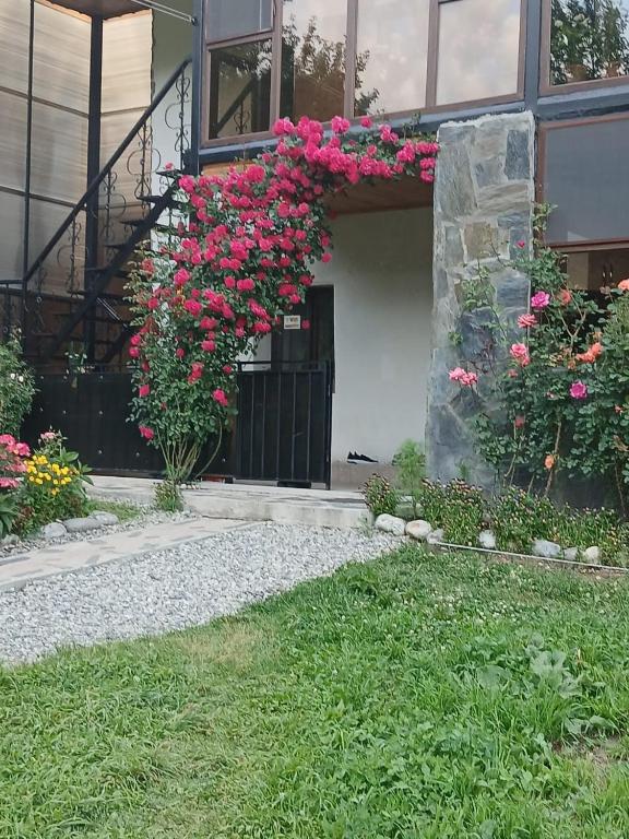 a house with pink flowers on the front of it at Guest House Nanu in Mestia