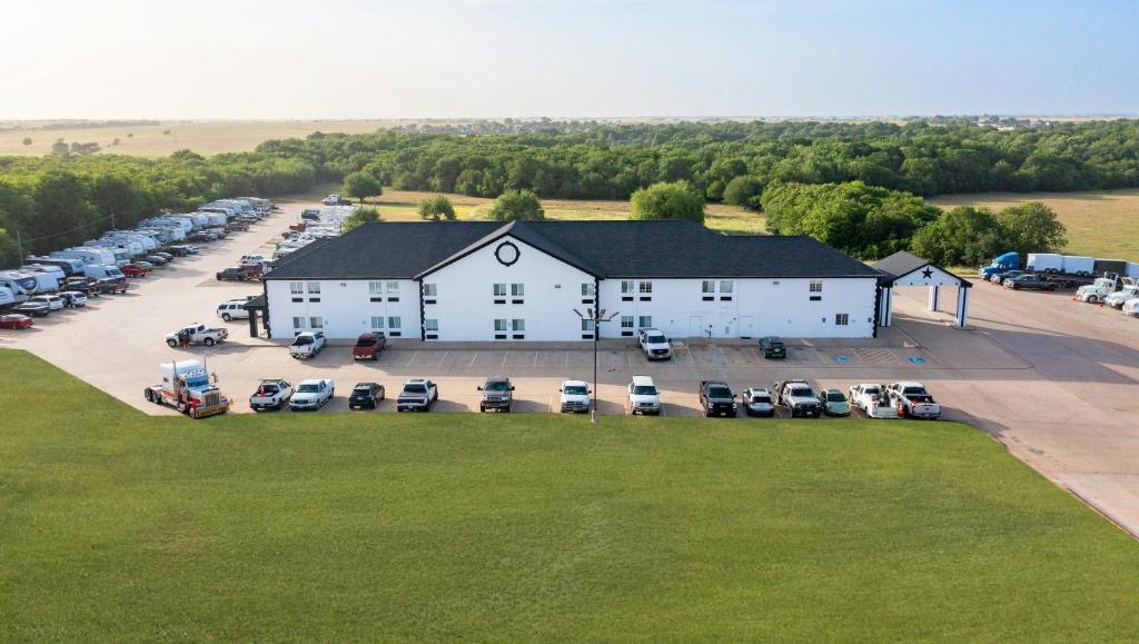 an aerial view of a large white building with a parking lot at Atria Hotel and RV McGregor in McGregor