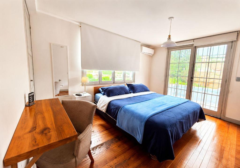a bedroom with a bed and a wooden table at MAKTVB BRASIL GuestHouse Hostel Boutique in Santiago
