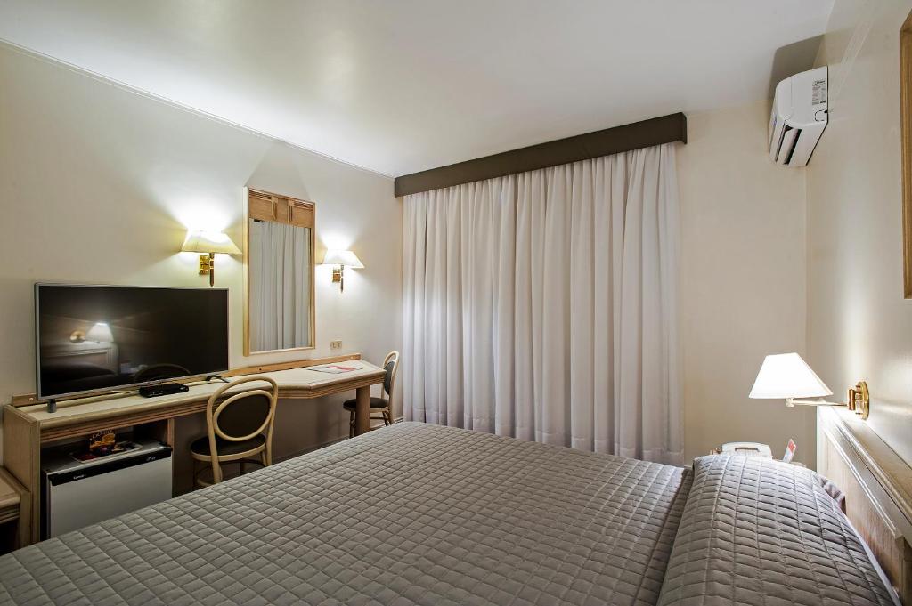 Postel nebo postele na pokoji v ubytování Trevi Hotel e Business