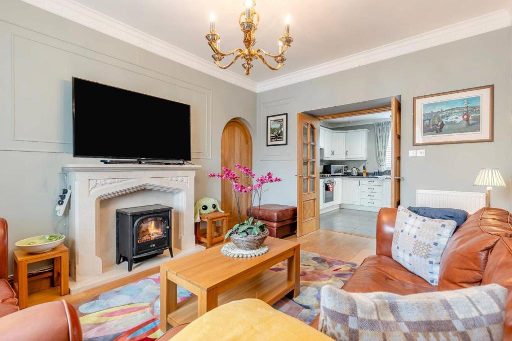 a living room with a fireplace and a flat screen tv at 3 Bed in Aberaeron oc-86578 in Aberaeron