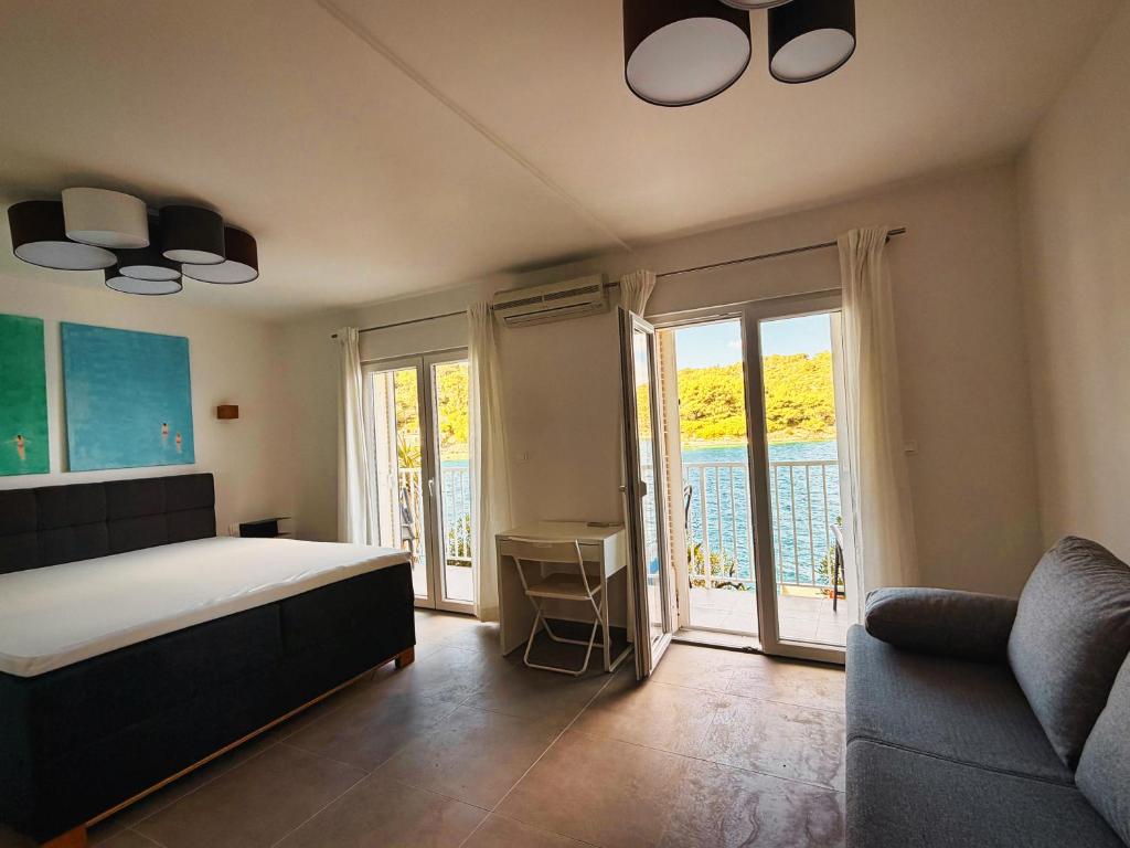 a bedroom with a bed and a couch at Apartman Blaga in Povlja