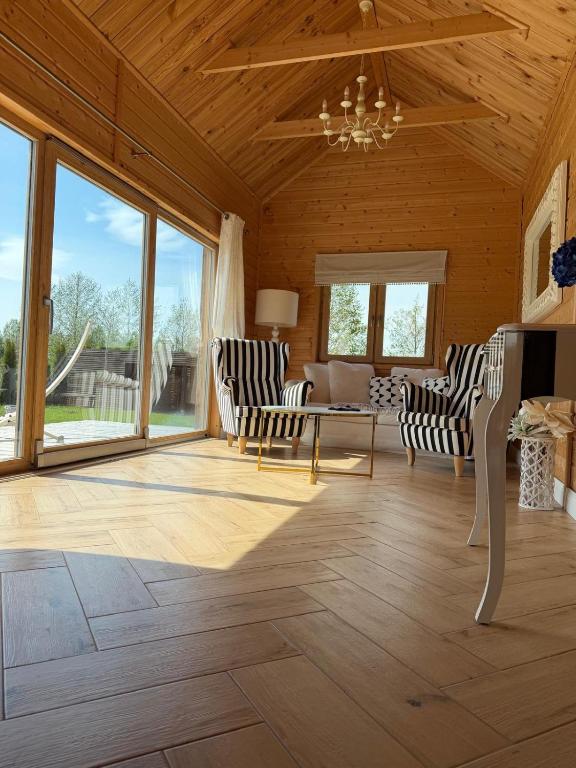 a living room with chairs and a table and windows at Luna House in Łoje