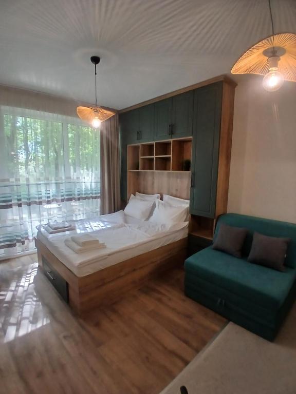 a bedroom with a large bed and a green couch at Studio ONE in Kiten