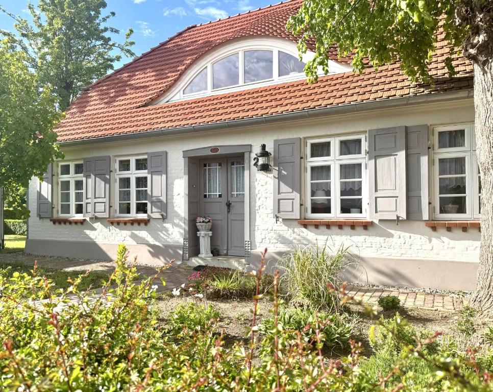 a white house with a red roof at Käpitänshaus zum Plümper in Ahrenshoop