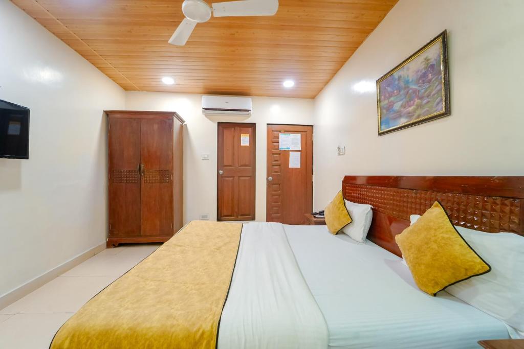 a bedroom with a large bed with yellow pillows at The New Hill Retreat in Mahabaleshwar