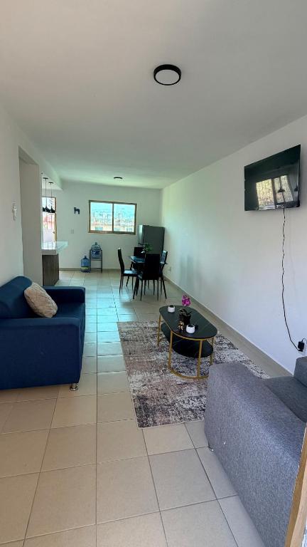 a living room with two blue couches and a table at Departamento scorpio in Tuxtla Gutiérrez