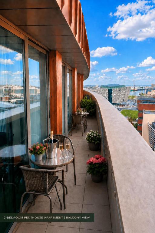 a balcony with tables and chairs on a building at CK Serviced Apartments, Titanic Quarter, Belfast in Belfast