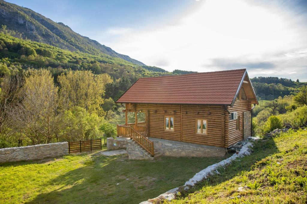 a log cabin on a hill with mountains in the background at Brvnara Vasić - Stara planina in Pirot
