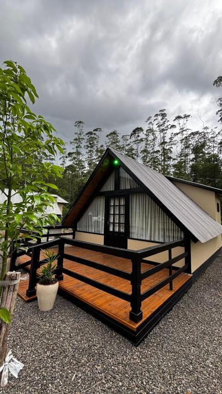 a small house with a gambrel roof at Sombra do baú - Aurora in Timbe do Sul