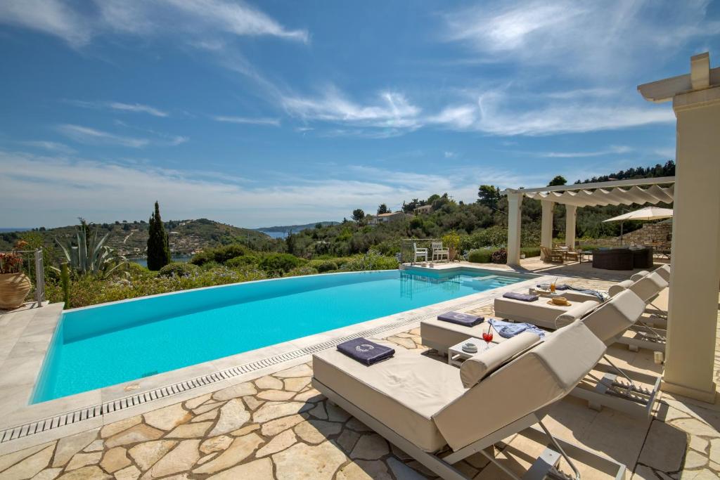a villa with a swimming pool and patio furniture at Andromeda Villa in Tranakatika