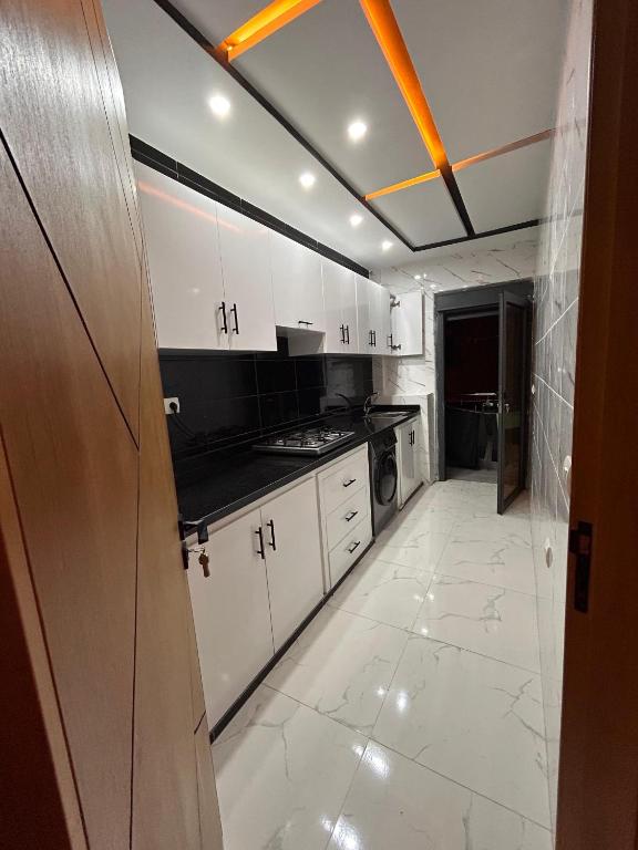 a kitchen with white cabinets and a stove top oven at Jaouhar immo in Martil