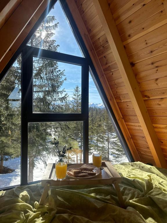 a bed and a table with two glasses of orange juice at Villa Tara in Žabljak