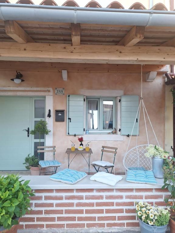 a patio with a swing and a table and chairs at Hiža Bepina in Marčana
