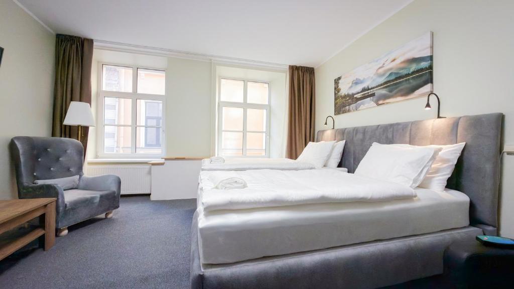 a hotel room with two beds and a chair at White Palace in Riga