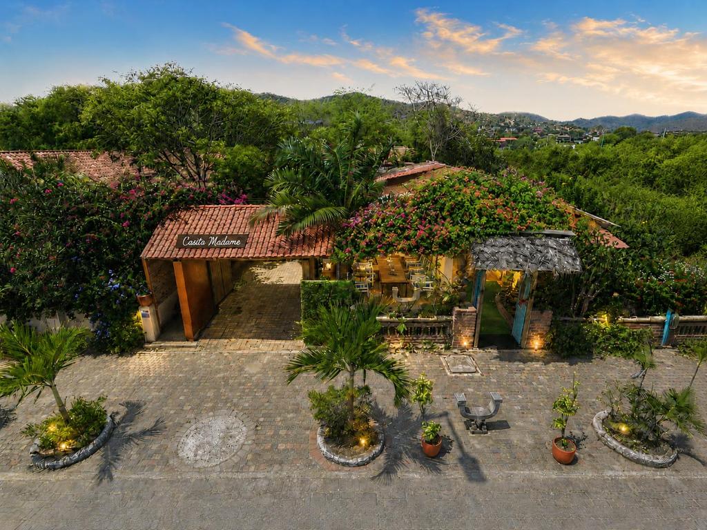 a building with potted plants in front of it at Casita Madame - Frente al Mar con Desayuno Gourmet in Puerto López