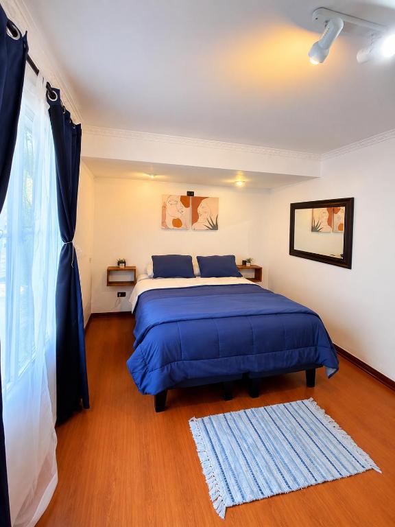 a bedroom with a blue bed and a window at MAKTVB COSTANERA Hostel Boutique cerca del Mall Costanera Center Providencia in Santiago