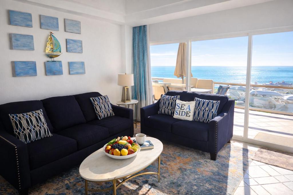a living room with a couch and a table with a bowl of fruit at Updated Beachfront Condo on Sandy Beach, Las Palmas Resort, 24hrs Security, Free Parking, Free Wi-Fi in Puerto Peñasco
