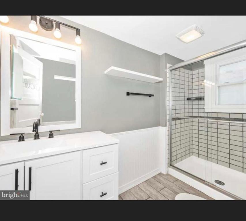 a white bathroom with a sink and a shower at Need a room i got you in Frederick