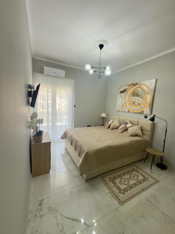 a bedroom with a bed and a painting on the wall at Eleni’s Mountainview Central Studio by the Sea in Loutraki