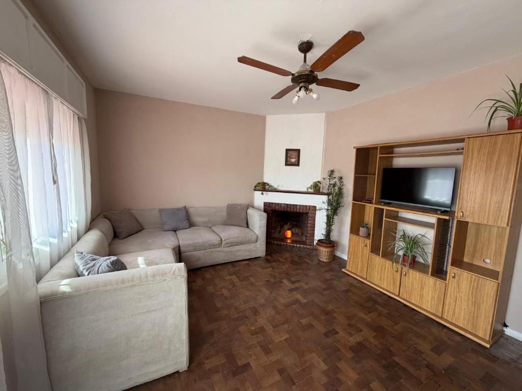 a living room with a couch and a flat screen tv at Hospedajes Edén in La Falda