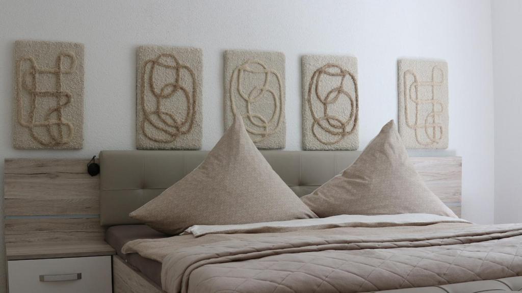 a bedroom with a bed with four pictures on the wall at Apartment Hornberg-Melisa in Hornberg