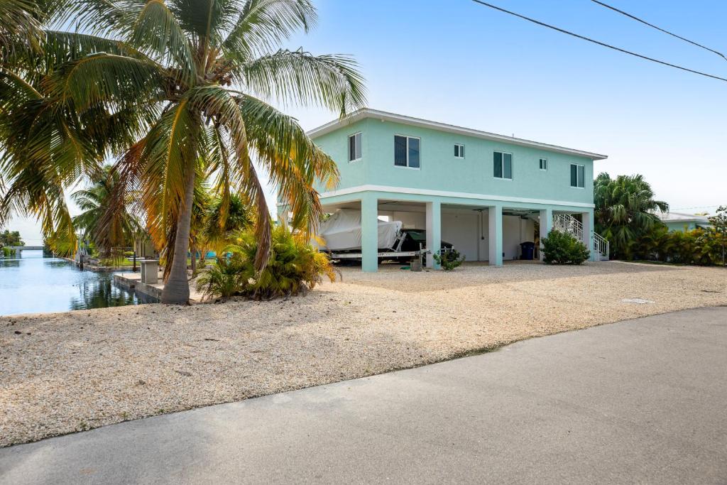 a house with a palm tree in front of it at BP04FLR Sunset Villa in Big Pine Key