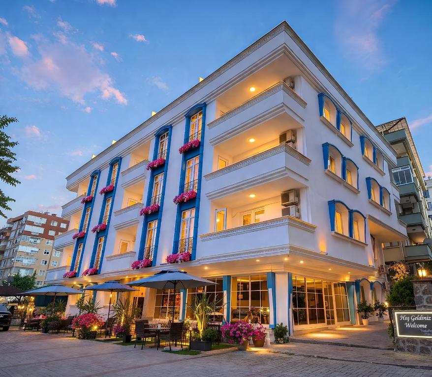 a large white building with tables and chairs in front of it at Anatolia Hotel Airport in Trabzon