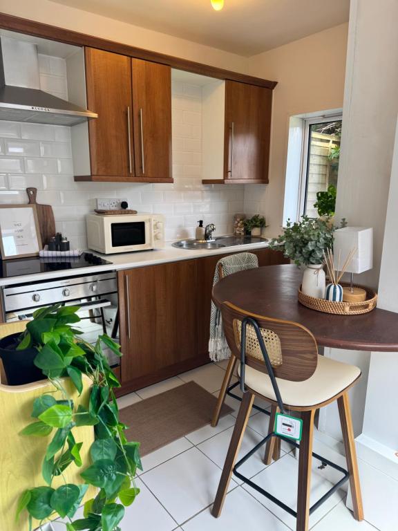 a kitchen with wooden cabinets and a wooden table and chairs at The Hidden Gem in Mablethorpe