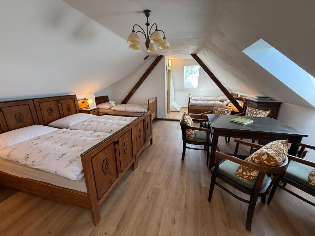 a bedroom with a bed and a table and chairs at Chalupa na Brdech in Obecnice