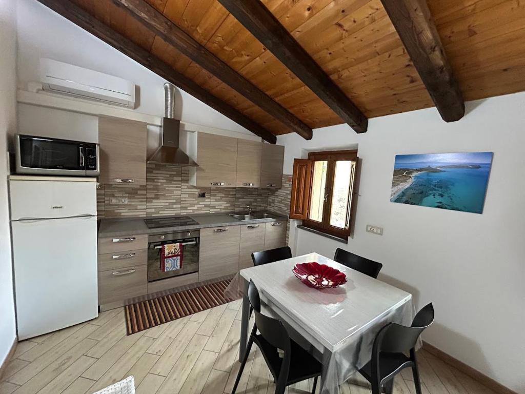 a kitchen with a table and chairs in a room at Casa Verde con servizio gratuito E-Bike in Seneghe