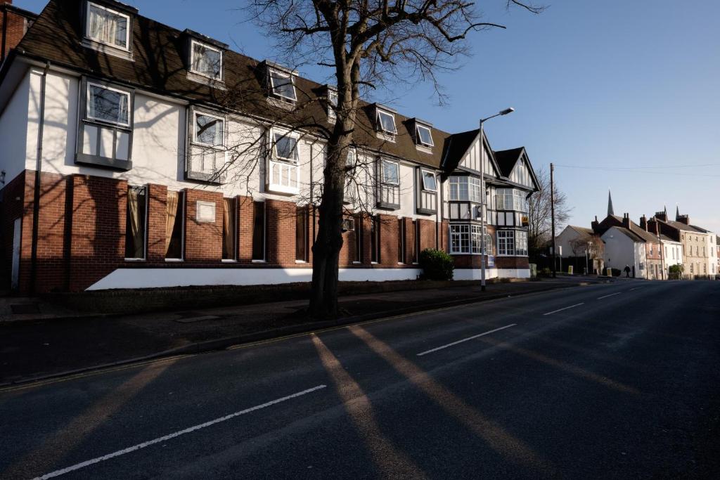 an empty street in front of a large house at The Cathedral Hotel in Lichfield