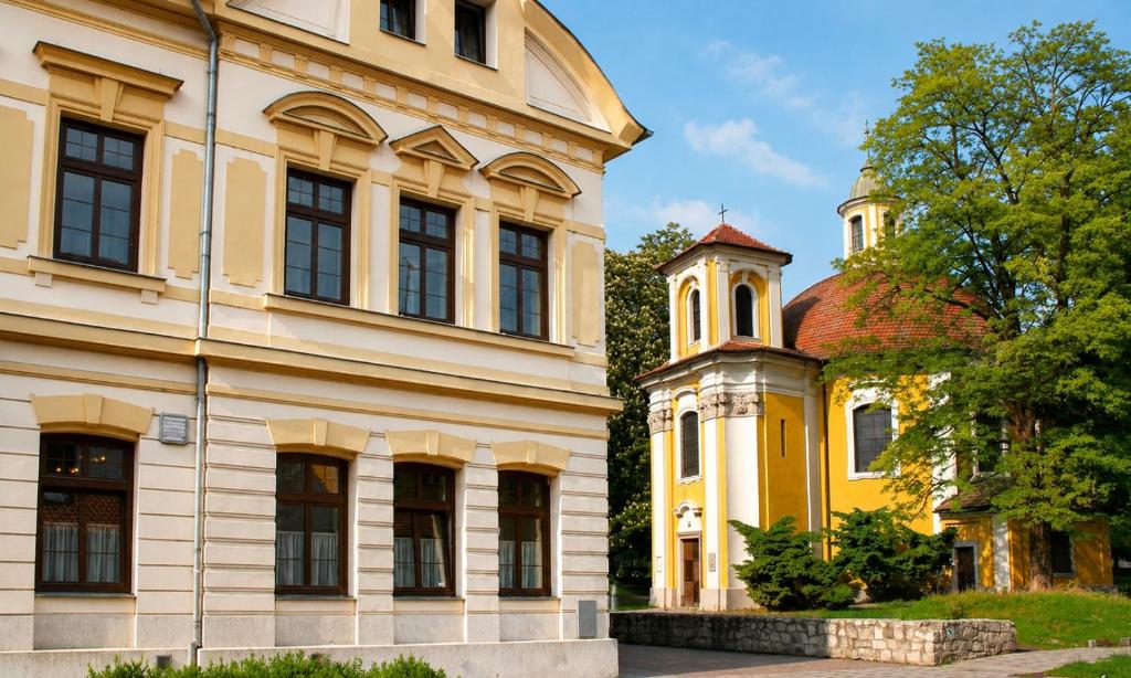 a yellow building next to a yellow building at Hotel Casanova in Duchcov