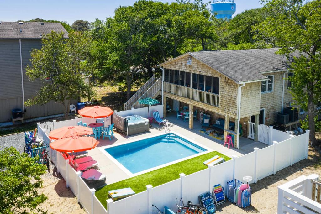 an aerial view of a house with a swimming pool with umbrellas at This Home Has It All Location Amenities & More in Duck