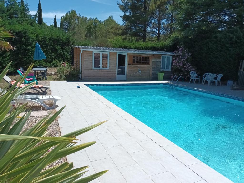 a swimming pool in a yard with a house at Appartement saumon 3p in Rognes