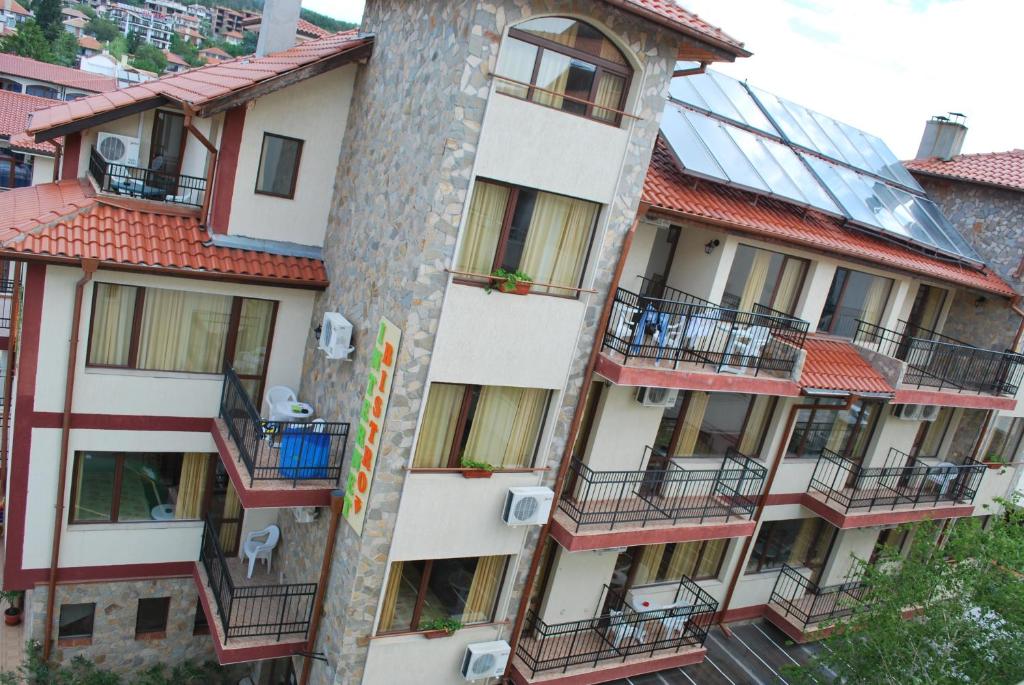 an apartment building with balconies and a solarium at Хостел Бреза in Sunny Beach