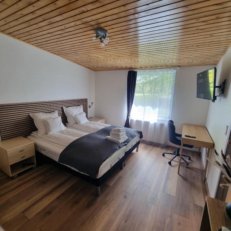 a bedroom with a bed and a desk and a window at Karlskovhuset in Give