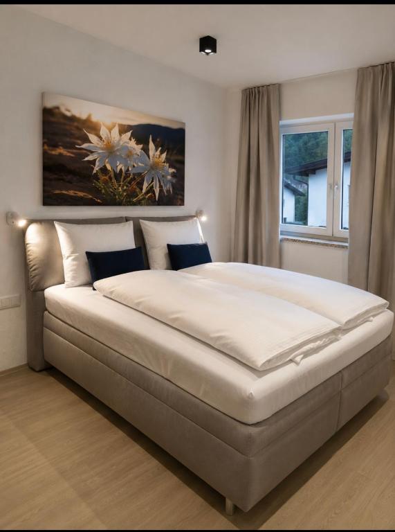 a bedroom with a large bed with white sheets at ONO Apartments in Längenfeld