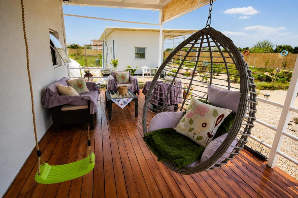 a porch with a swing and chairs on a deck at Agroktima Arta - Farm Stay in Arta
