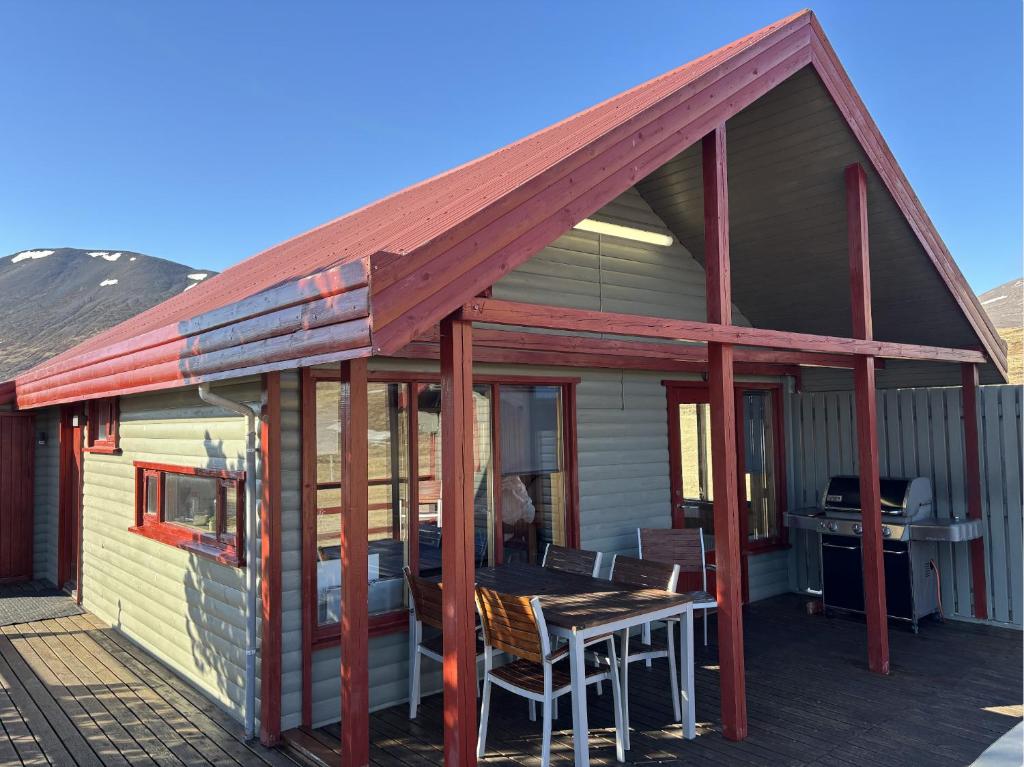 a house with a roof with a table on a deck at Summerhouse Torfalundur in Blönduós