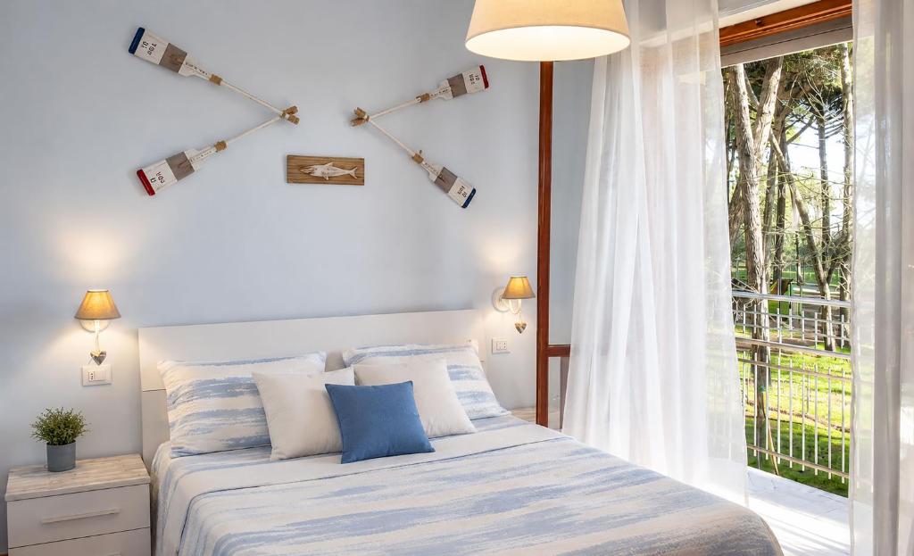 a bedroom with a bed with blue pillows and a window at I Velieri in Cesenatico