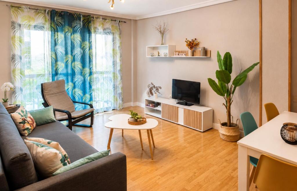 a living room with a couch and a tv at El Refugio de Yetana Centro ciudad con parking in Cartagena