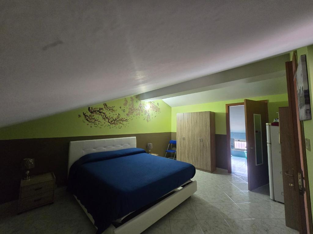 a bedroom with a blue bed and green walls at A Casa di Nonna in Riposto