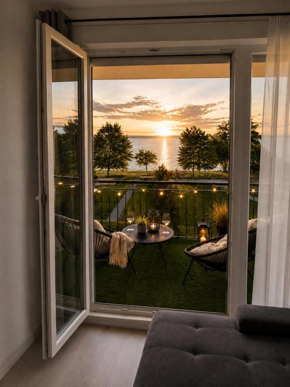 a room with a large window with a view of a patio at Citadella Luxury Lakefront Apartment with Terrace in Siófok
